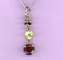 Silver 3 Stone GARNET & PERIDOT  Pendant featuring: a 4mm GARNET, a 5mm PERIDOT and a 6mm  GARNET on an 18" Silver Chain. Total Caret Weight: 1.8 cts.